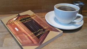 A book titled "The Kinetoscope: A British History" is placed beside a cup of tea. The book's cover features a kinetoscope, with the film winding it's way through.