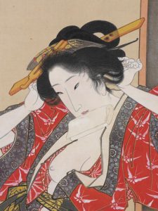 A woman fixing her hair, her robe partly open and one breast exposed, with a packet of tissue paper between her teeth.
