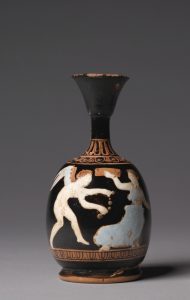 An ancient vase, painted in black, with ornaments and paintings of Eros as a winged man approaching a woman in a white tunic.