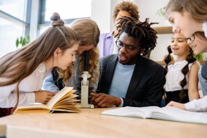 Teacher and children using a microscope