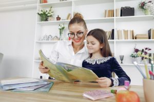 Girl and teacher reading together