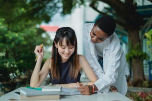 Teacher helping girl with writing