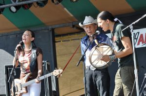 Jeneda and Clayton Benally of Sihasin with their father Jones performing on stage at GrassRoots Festival in 2012.