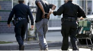 Police officers arrest a homeless man for possession of a stolen shopping cart during a sweep of Skid Row in downtown Los Angeles.