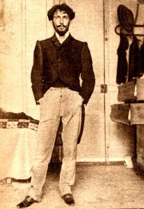Sepia toned full body portrait of Horacio Quiroga in a suit with hands in his pockets.